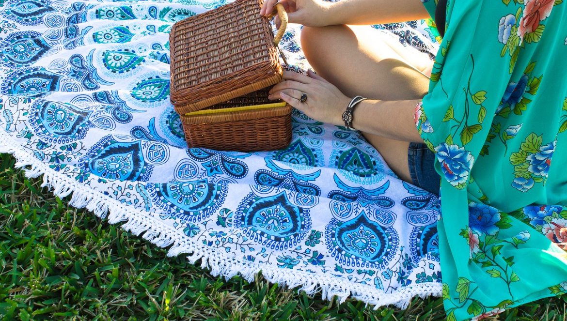 woman with picnic basket sitting on blanket in a park