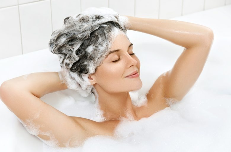 woman washing hair with treatment shampoo in the bath
