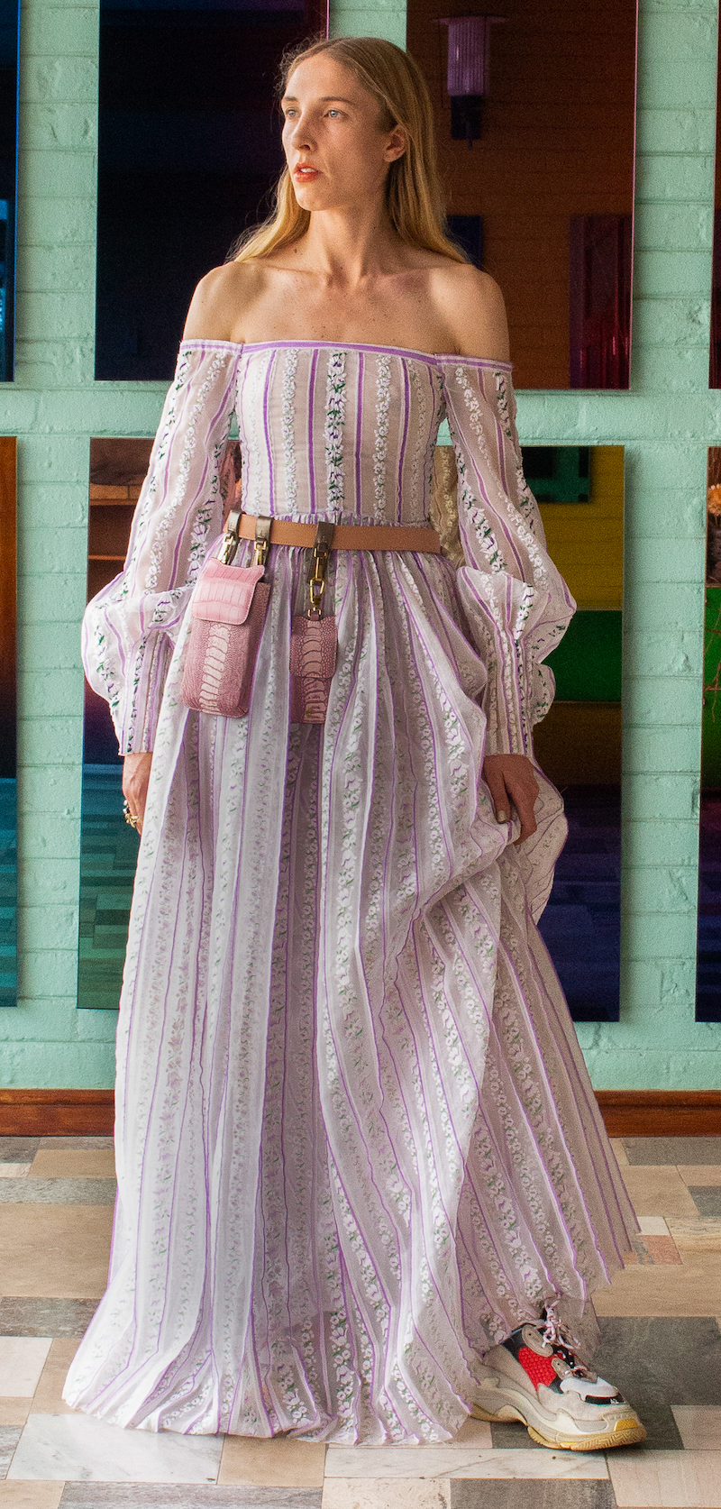 Woman wearing a lilac embroidered off-the-shoulder full length, long sleeved dress