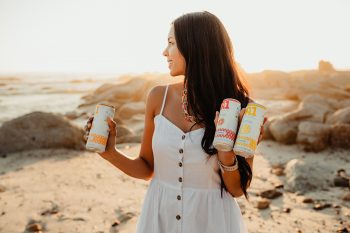 Woman holding A1 fruit Water cans on beach