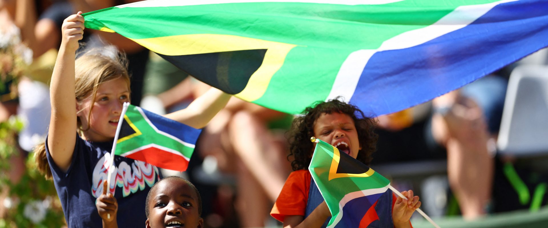 three children waving the South African flag