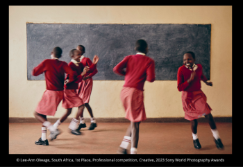 girls in school uniforms playing in a classroom