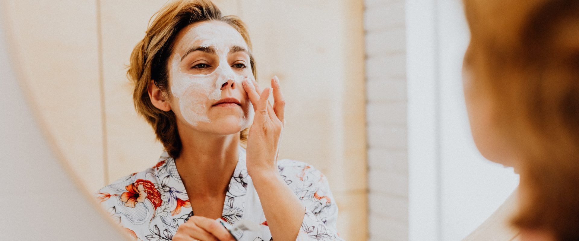 a woman applying skincare products to her face