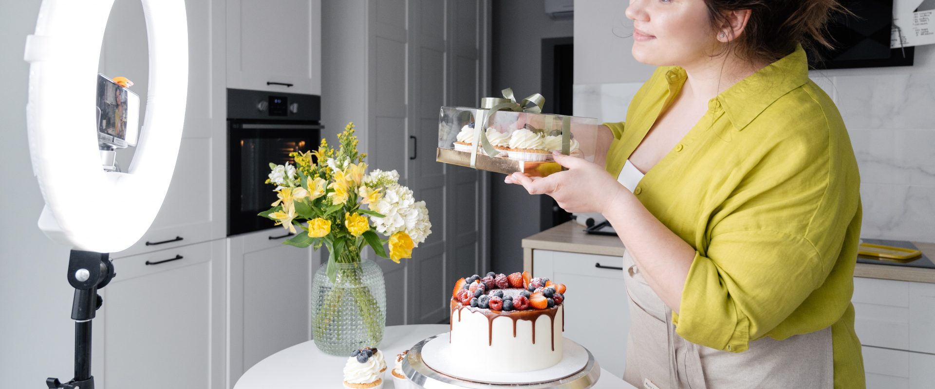 a woman recording a video on her phone in her kitchen