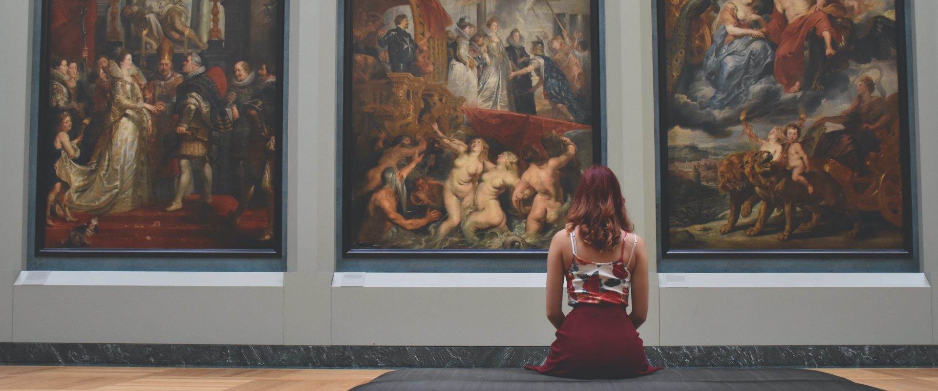 girl sitting on a bench at a museum
