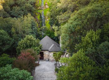 a lodge positioned in front of a waterfall