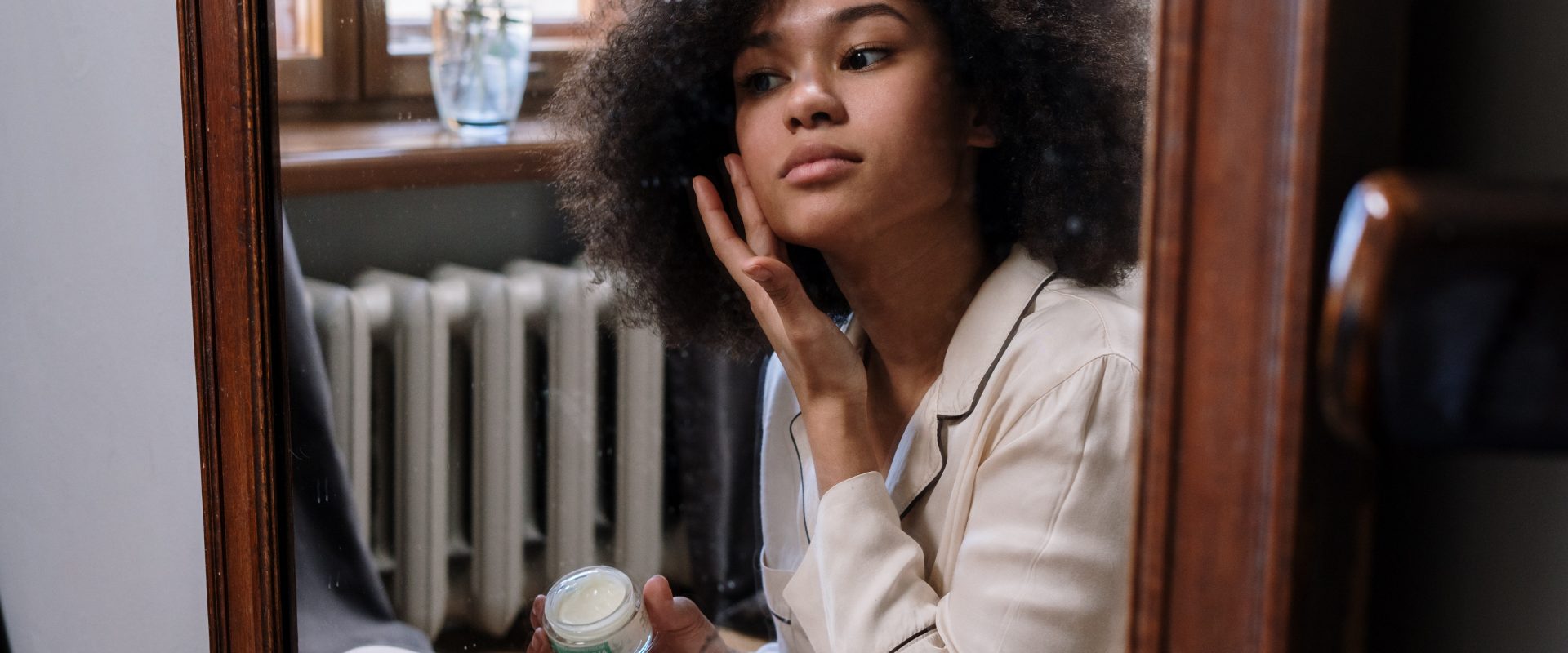 a woman applying product to her face