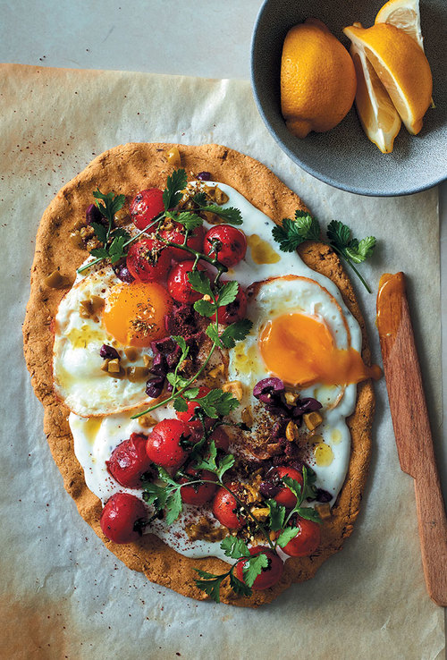 Chickpea flour flatbread with garlicky yoghurt, fried eggs, vine tomatoes and olives